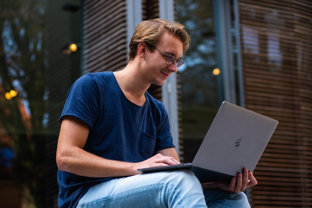 Siedzący mężczyzna pracujący na laptopie